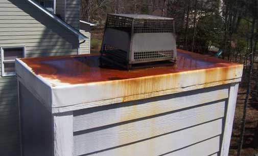 Vinyl Sided Chimney with Rusted Chimney Chase Cover Before Repair