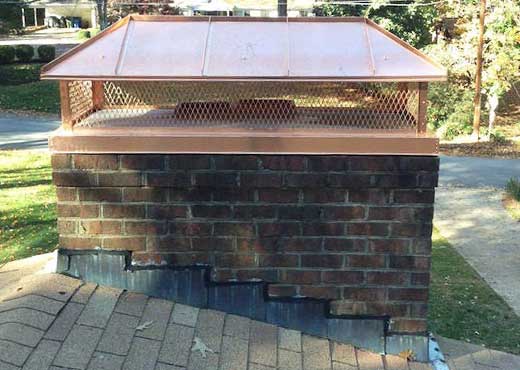 Brick chimney with newly installed custom double flue copper chimney cap