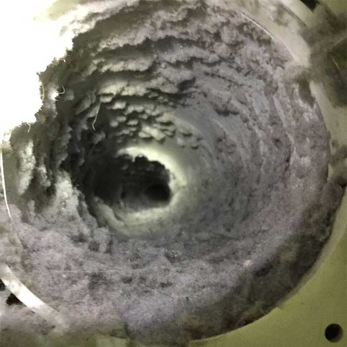 Close up view inside dryer vent showing dirt and debris build up