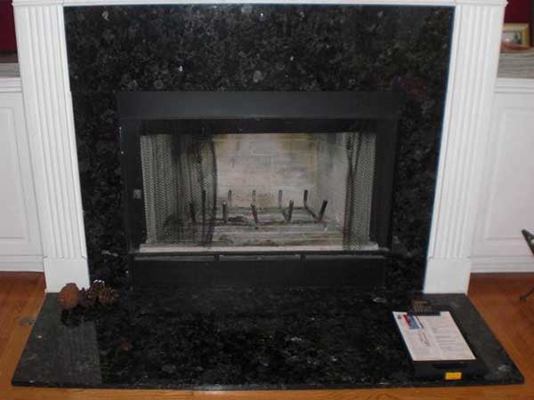 Fireplace with black marble surround with damaged and dirty firebox  before repair