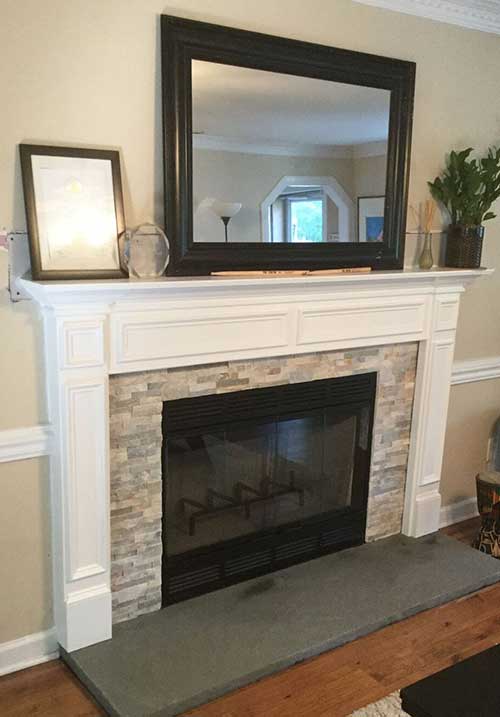 Completed new firebox installation with stacked stone surround and white mantle 