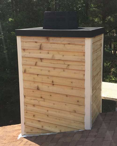 renovated chimney with pine siding, black metal crown and chimney cap