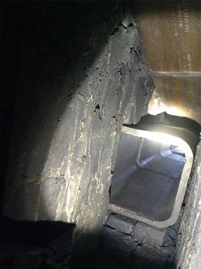 Close up of damaged chimney flue with missing and broken flue pipe sections