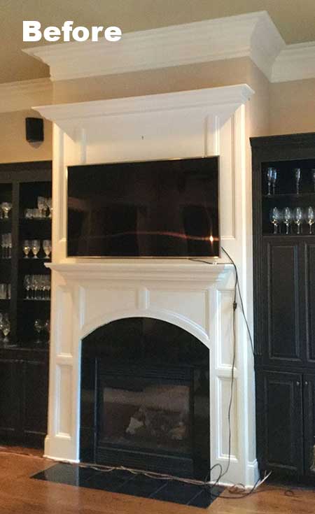 Fireplace with black insert, white wood surround and mantle with TV mounted before restoration and installation