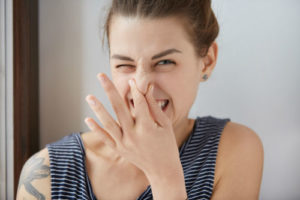 woman smelling something bad