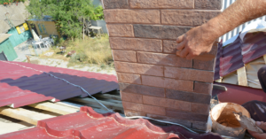 Man waterproofing outside of chimney