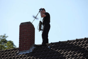 sweep on roof inspecting chimney