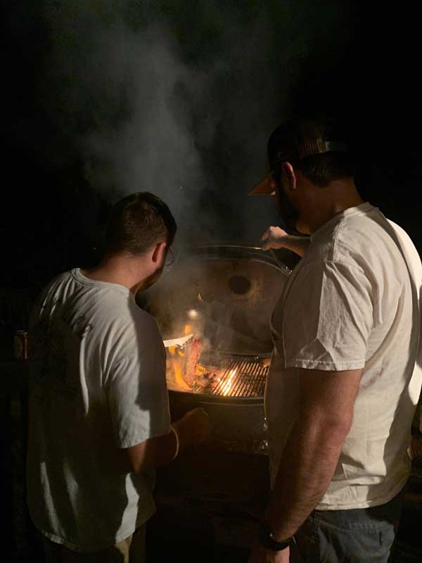 guys enjoying outdoor grilling at night