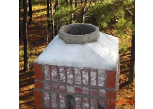 Brick chimney with exposed flue before custom chimney cap installation