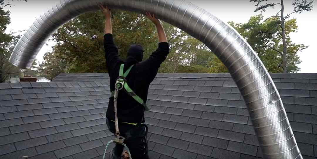 Chimney Technician Carrying Chimney Liner over roof