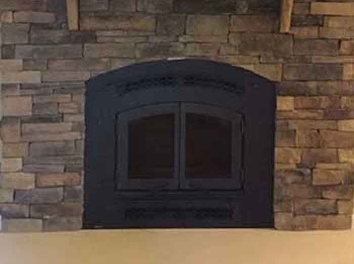 Fireplace Retro Fit After with new black arched insert with same stone surround, wood mantel and upgraded smooth heath