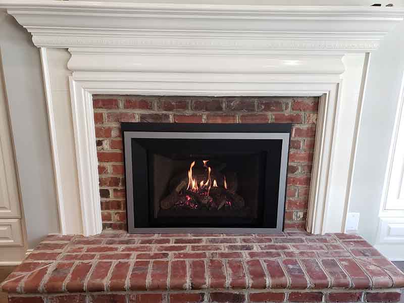 Brick Fireplace with white mantle with restored firebox, new faceplate and dazzling flame