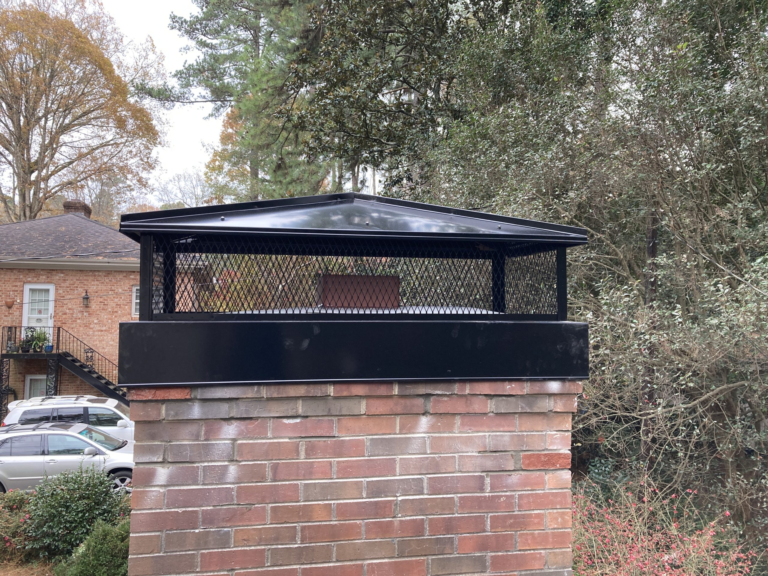 Brick Chimney after new, larger black metal chimney cap, with screen and chase cover installation