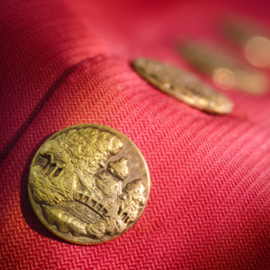 close up of brass buttons on a red coat