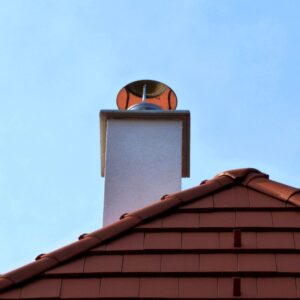 white chimney with a shiny, metal single flue cap