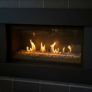 a lit wide gas fireplace with a blame frame