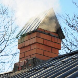 smoke coming out of a masonry chimney with a roof-like cap