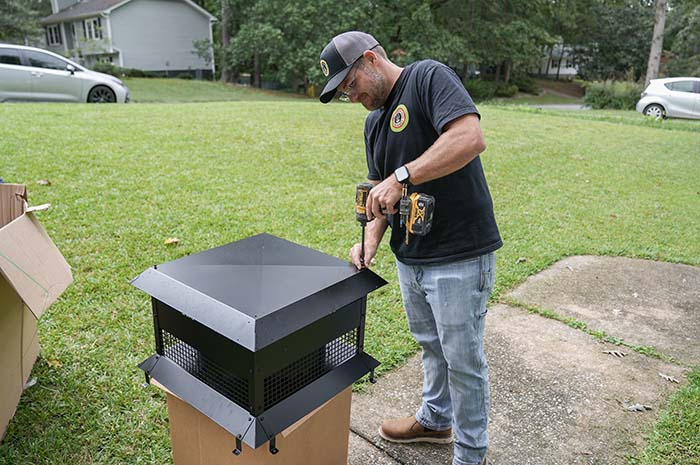 Technician putting chimney cap together 